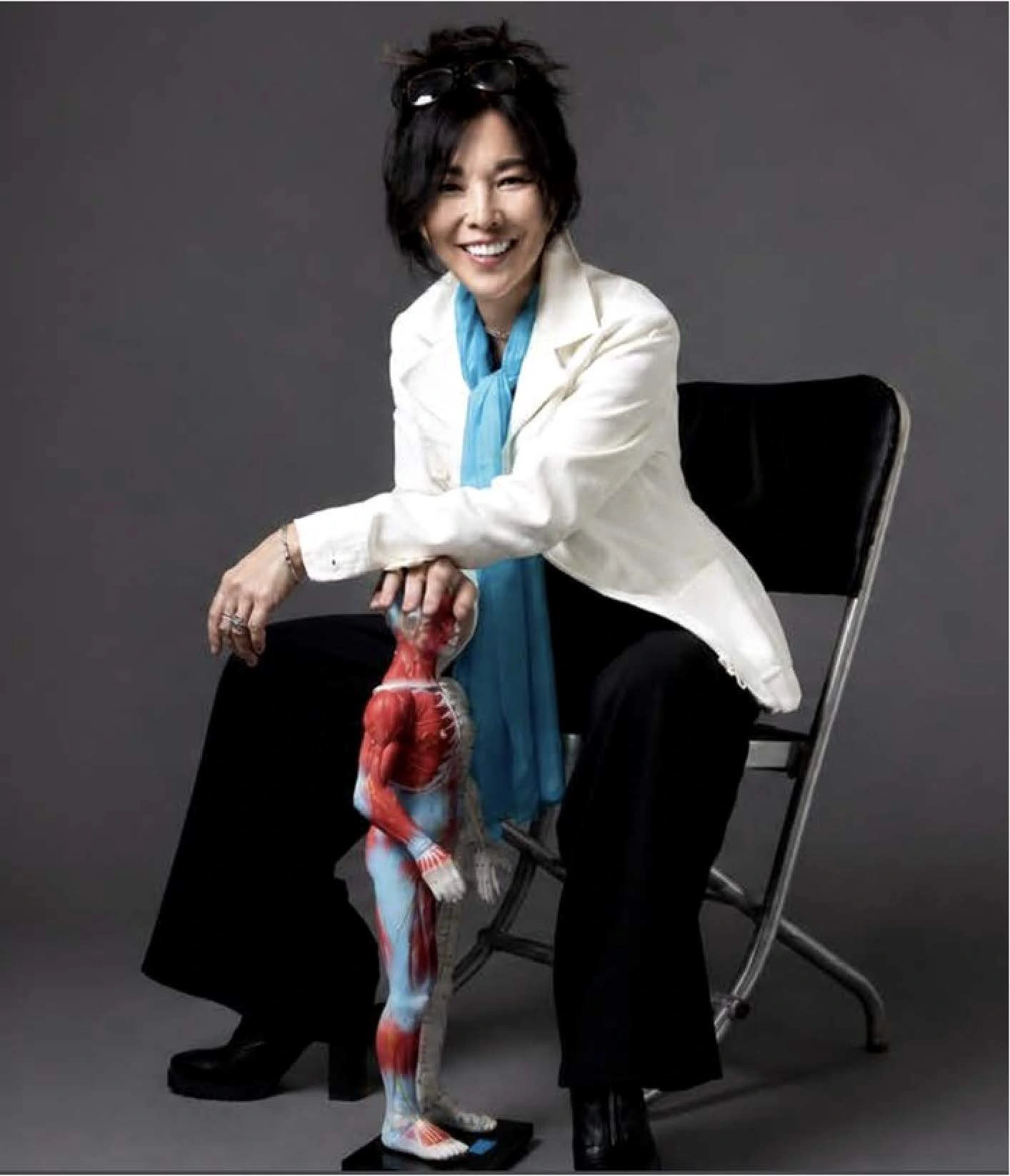 Dr. Jayne Tsuchiyama seated beside an anatomical model